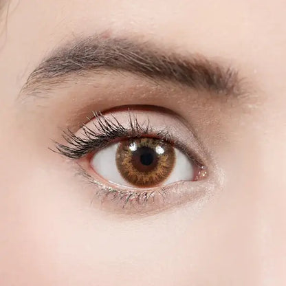 Close-up of a person's brown eye with detailed eyelashes and skin texture.